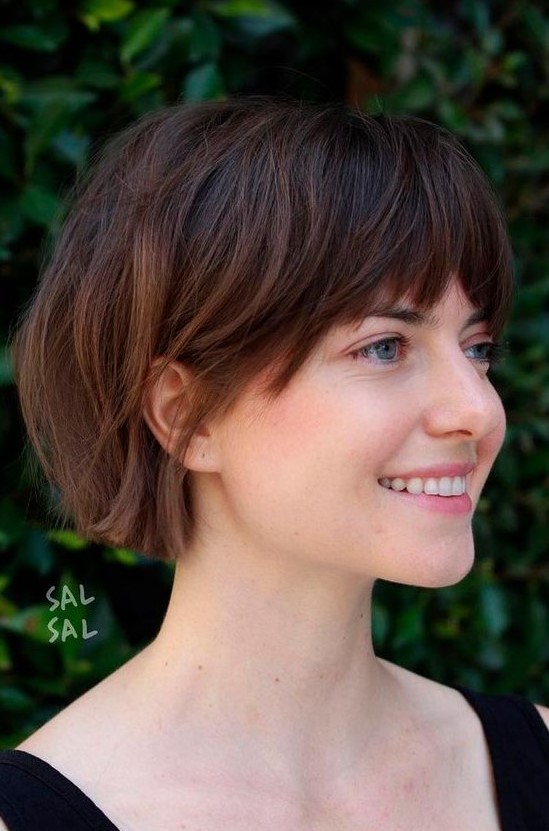 a dark brunette jaw-length bob with caramel balayage and layered bangs is a catchy idea to rock right now