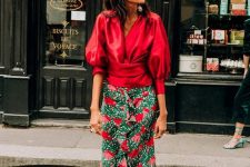 a deep red puff sleeve blouse, a green and red floral midi skirt, blue strappy heels for a fall wedding in bright shades