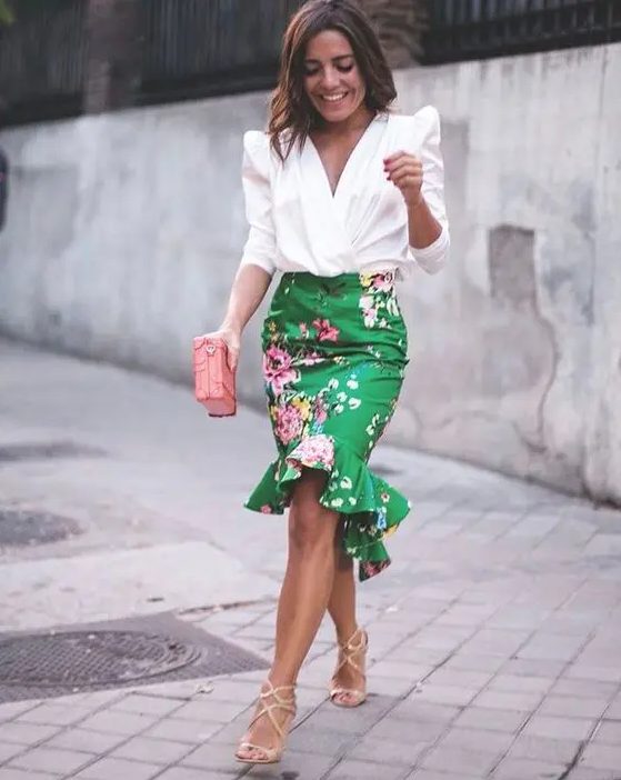 a floral peplum high low green skirt, a white blouse with statement sleeves, strappy heels and a pink clutch