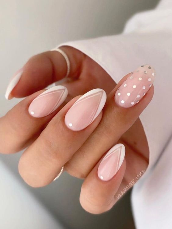 a fun version of Frenhc manicure on long lamond nails with white geo tips, polka dots and a single polka dot accent nail