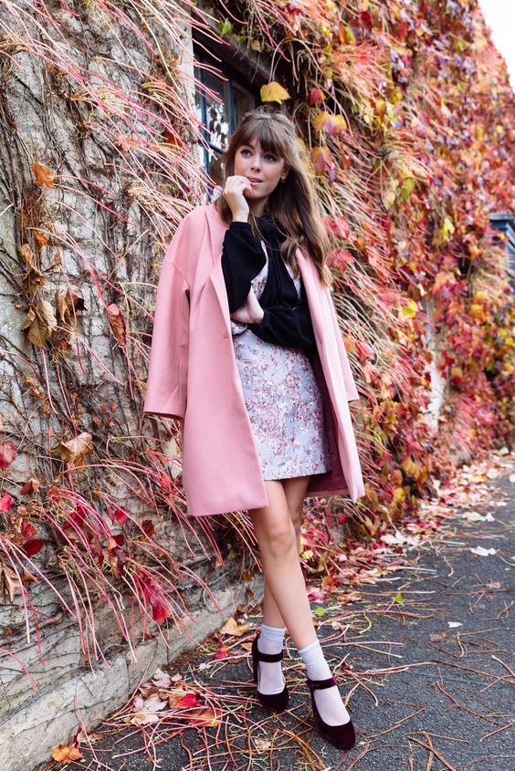 a girlish look with a black long sleeve top, a pastel floral mini, white socks, burgundy velvet Mary Jane shoes, a pink trench