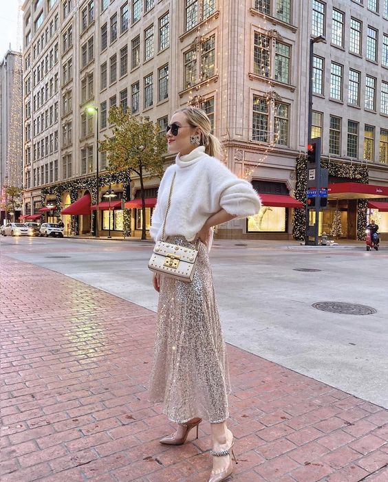 A glam pre wedding party look with a white oversized sweater, a silver sequin A line skirt, nude shoes and a white bag
