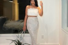 a glam pre-wedding party outfit with a feather crop top, a silver pattern sequin midi, silver embellished shoes and a bag