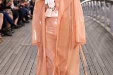 a gorgeous Peach Fuzz look with a leather dress and a sheer trench, tan shoes and a small white bag