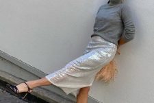 a grey turtleneck, a silver sequin midi skirt, black heels and a peachy pink feather bag for a party