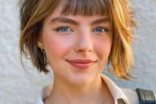 a layered bob with brighter locks and small, baby bangs looks super cute and very young