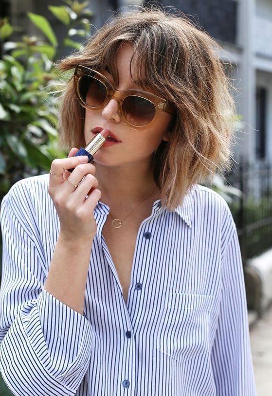 a lovely light brunette shaggy long bob with caramel balayage and a lot of texture plus curtain bangs is cool