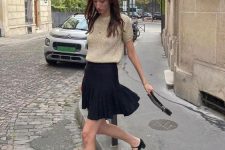 a lovely look with a tan top, a black mini skirt, black Mary Jane shoes and a small bag