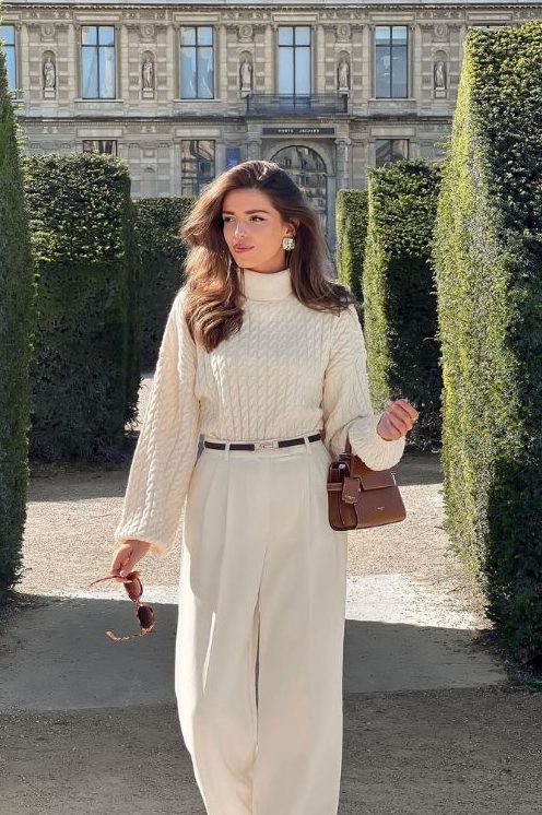 a lovely old money outfit with a creamy sweater, wideleg pants, statement earrings and a small brown bag