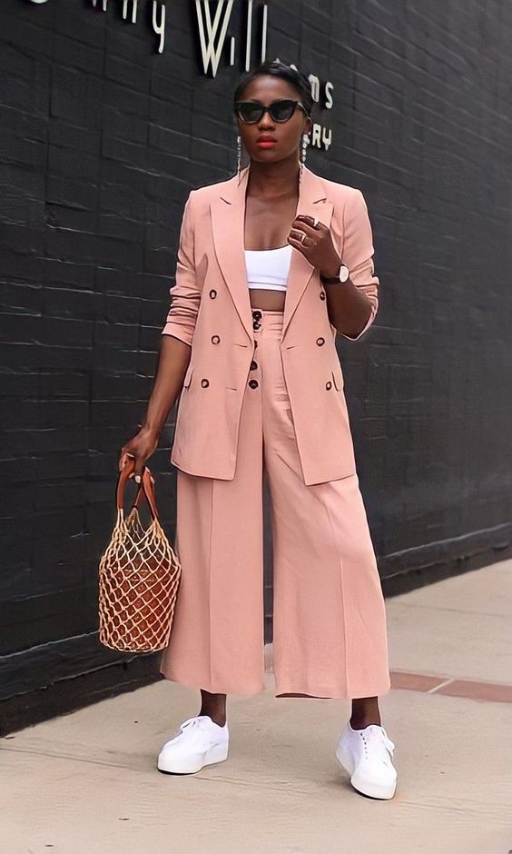 a lovely peachy pink pantsuit with culottes, an oversized blazer, a white crop top, white sneakers and a bucket bag