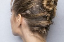 a messy ballerina bun made on top and with messy hair secured to keep it in place