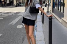 a minimal chic look with a white t-shirt, a grey waistcoat, a black mini, black lacquer Mary Jane flats and a small black bag