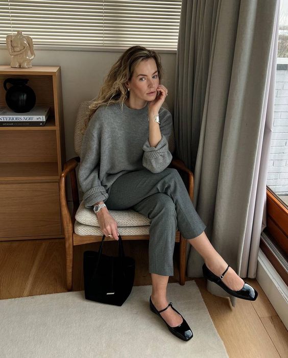 a minimal work look with a grey oversized jumper, grey pants, black lacquer Mary Jane flas and a black bag