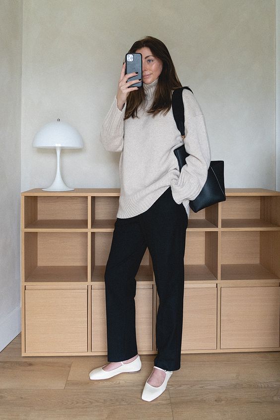 a minimalist outfit with a creamy sweater, black trousers, a black tote and white Mary Jane shoes