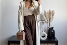 a neutral bodysuit, a matching maxi cardigan, brown pants and a small woven bag for a quiet luxury look