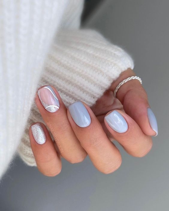 a pastel blue manicure with a swirl accent nail and a silver glitter one is a cool idea for spring