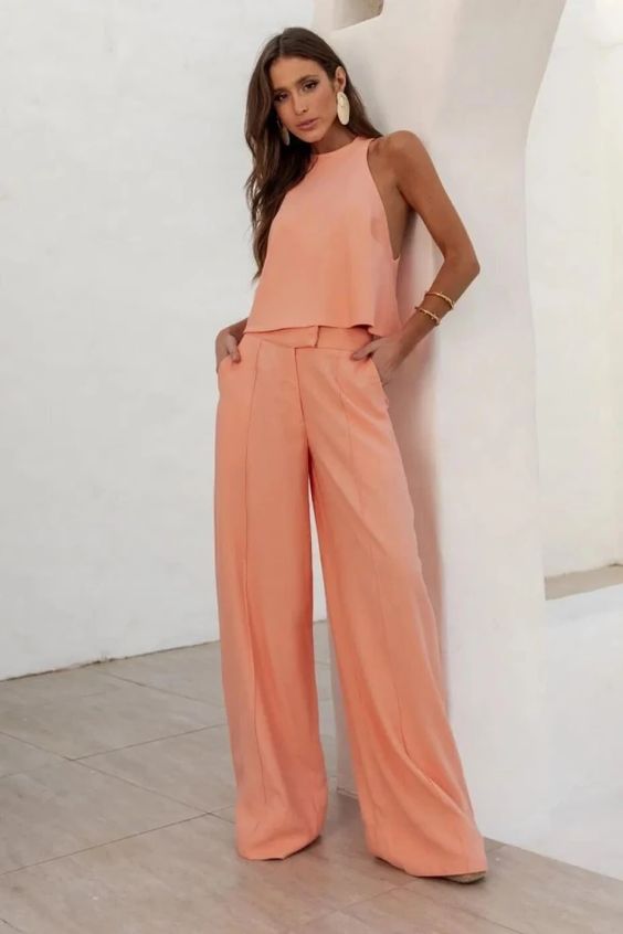 a pretty outfit for spring and summer done in peach Fuzz, a halter neckline top, wideleg pants, statement accessories