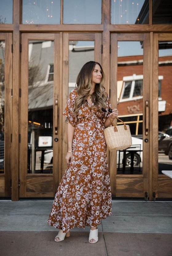 a pretty rust-colored floral maxi dress with short sleeves, white mules, a basket bag for a relaxed wedding guest look