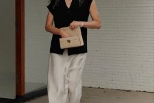 a quiet luxury look with an oversized black cap sleeve top, neutral culottes and strappy shoes plus a small tan bag