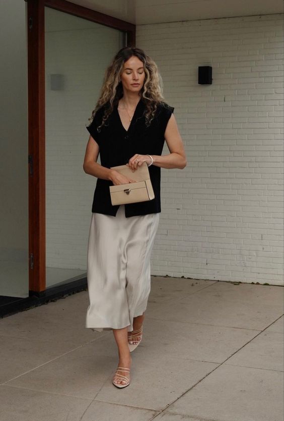a quiet luxury look with an oversized black cap sleeve top, neutral culottes and strappy shoes plus a small tan bag