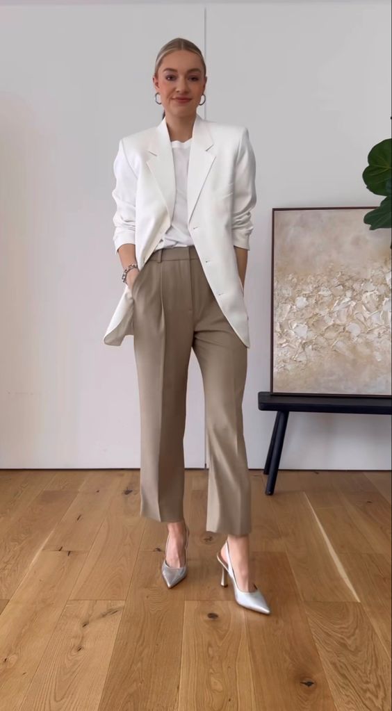 A quiet luxury outfit with a white t shirt, an oversized white blazer, taupe cropped pants, silver slingbacks