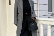 a refined work quiet luxury outfit wiht a black turtleneck, black skinnies tucked into knee boots, a grey midi coat and a black bag