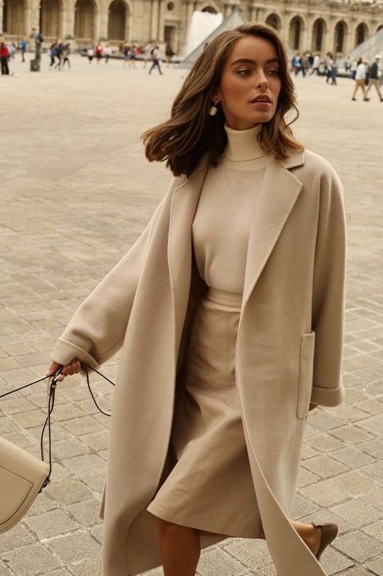 a romatic and minimal fall look with a creamy turtleneck, a beige leather skirt, a neutral coat and a semi circle bag