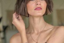 a short light brunette bob with a bit of waves and curtain bangs is a lovely idea that looks cute and cool