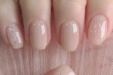 a short square nude manicure with glitter and a single dried flower is a super chic and delicate idea for spring