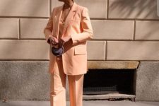 a stylish Peach Fuzz look with a pantsuit, an oversized blazer, a top, green shoes and a necklace plus a tiny bag