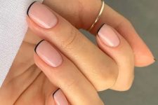 a super delicate and pretty barely there French manicure with nude nails and black tips
