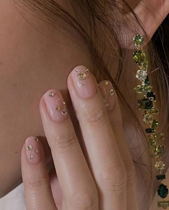 a super glam wedding manicure in blush, with large gold rhinestones is amazing for a glam look at a NYE party