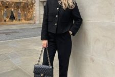 a total black look with a cropped blazer with accented buttons, cropped pants, slingbacks and a bag with chain