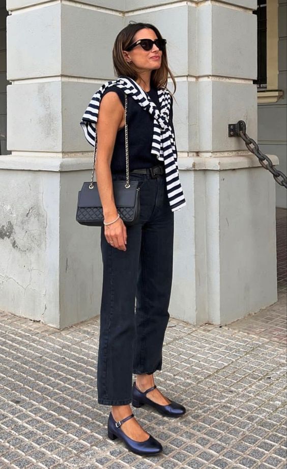 a total black look with a sleeveless tee, jeans, Mary Jane shoes, a bag and a striped long sleeve top