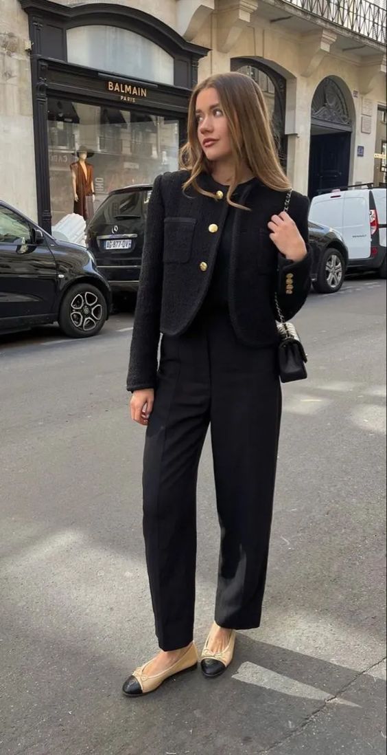 A total black old money look with a top, trousers, a cropped blazer, two tone shoes and a small bag for fall or winter