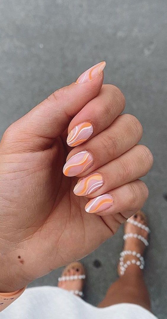 a trendy almond-shaped manicure with an abstract pattern, with white and Peach Fuzz touches
