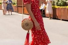 a vintage-styled red floral midi dress with short sleeves and a V-neckline, red heels and a straw bag