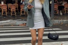 a white fitting mini dress, a grey oversized blazer, black lacquer Mary Jane shoes and a small black bag