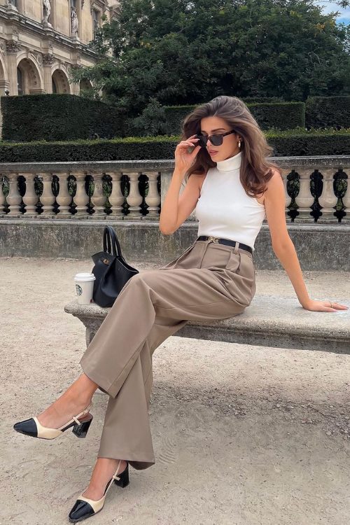 A white high neckline sleeveless top, taupe trousers, two tone slingbacks and a black bag for a chic old money look