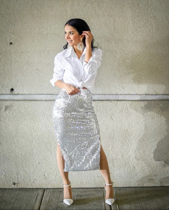 a white knotted button down, a silver sequin midi skirt with two slits, white shoes and statement earrings