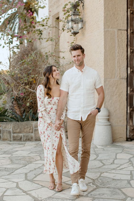 a white midi floral dress with long sleeves, a square neckline, a slit and flat shoes for a summer wedding