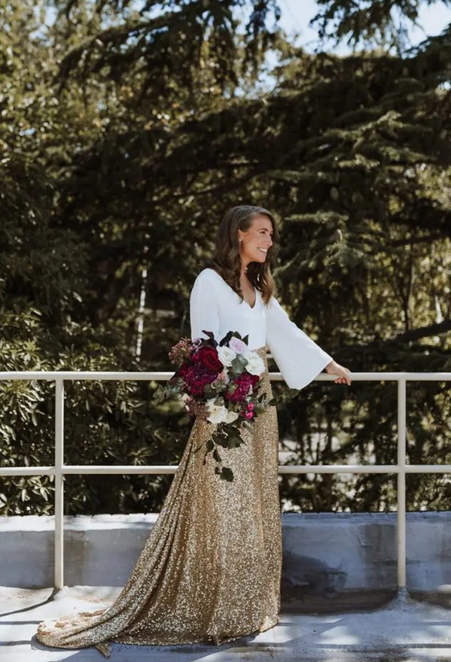 a white top with bell sleeves and a gold glitter skirt with a train can be rocked a s asecond wedding ensemble or for a bridal shower