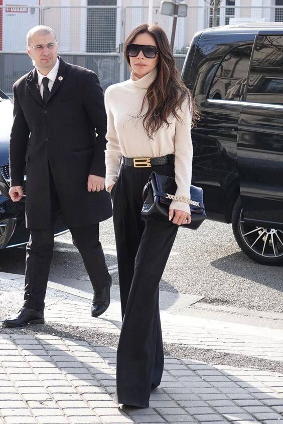 A white turtleneck, black high waisted flare trousers, a black belt and a black bag are perfect for a quiet luxury look