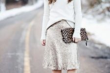 a white turtleneck sweater, a silver sequin A-line skirt, nude shoes and a leopard printed clutch