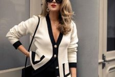 a work old money look with black trousers, a black and white cardigan with accented buttons, statement earrings and a small black bag