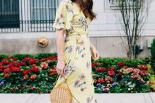 a yellow wrap maxi dress with short sleeves, beige strappy shoes, a round wicker bag for a spring or summer wedding