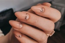 almond-shaped nude nails with delicately painted black branches and leaves are amazing for a delicate bridal look