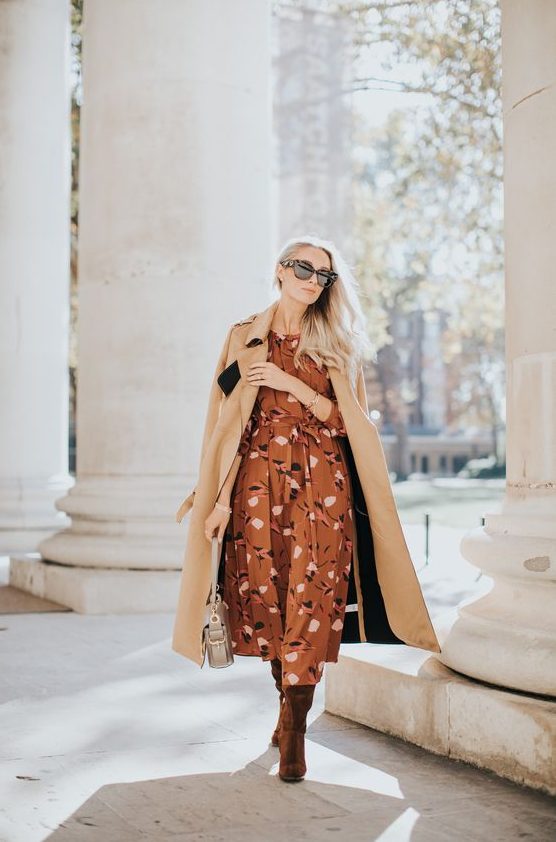 an elegant fall wedding guest look with a brown printed midi dress, burgundy velvet boots, a beige coat and a neutral bag