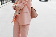 an everyday work look with a peachy pink pantsuit, a white t-shirt, white sneakers and a tan bag with chain
