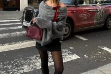an eye-catchy look with a grey off the shoulder sweater, a black mini, black tights, grey socks, red Mary Jane shoes and a burgundy bag